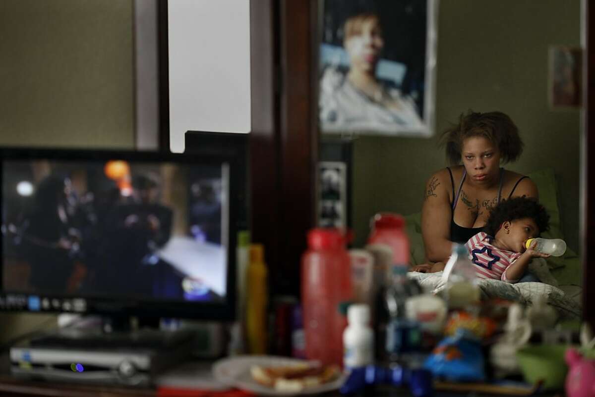 Brijjanna Price watches television while holding her daughter after having a fight with her boyfriend Quindell Anderson on Wednesday, November 6, 2013, in Hayward, Calif. Photo: Lacy Atkins, The Chronicle