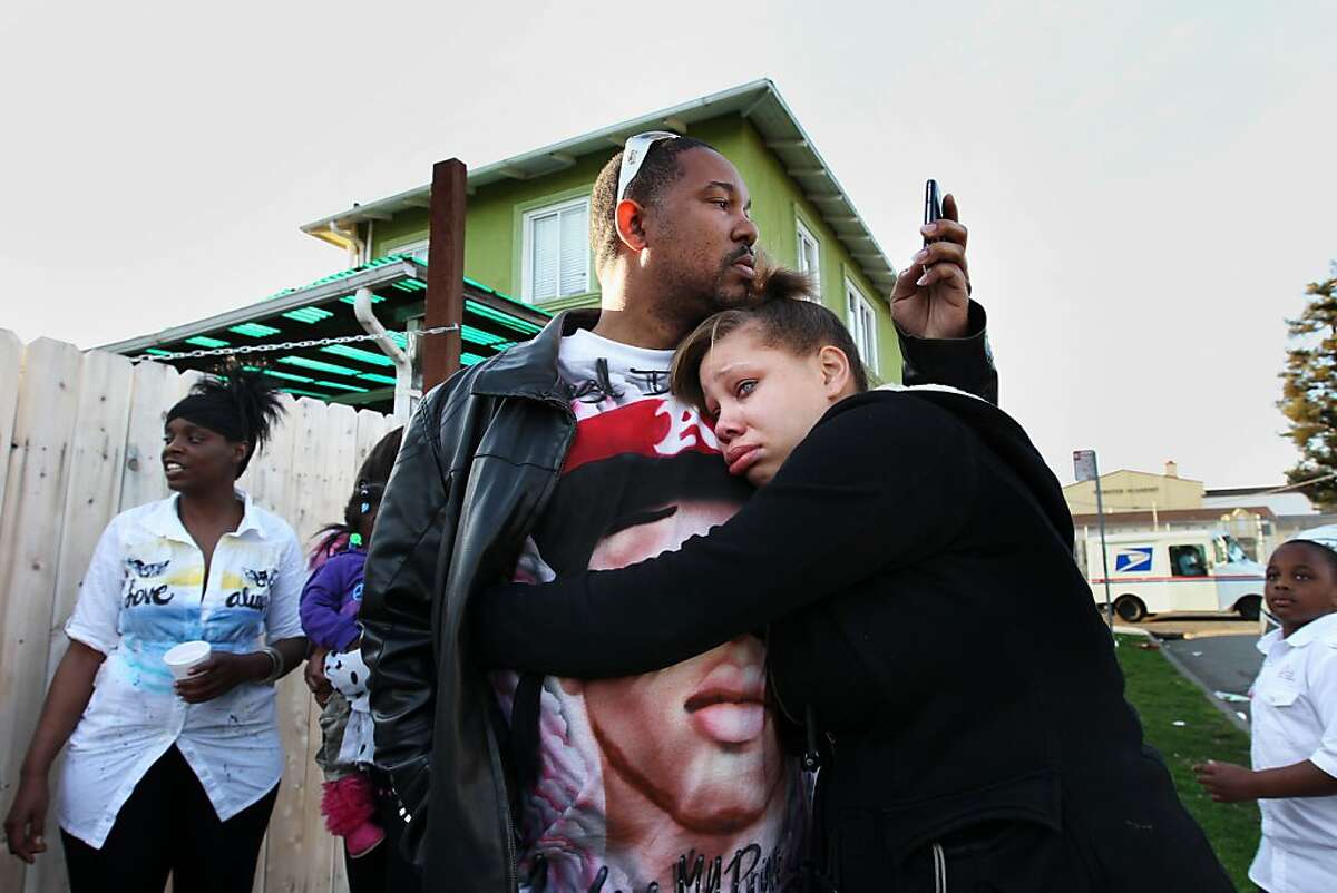 Brijjanna Price, 17, seeks comfort  from her father Ramon Price Sr. during the vigil marking the one year anniversary of her brother Lamont's killing, Saturday February 16, 2013, in Oakland, Calif. Lamont Price, 17, was one of the 131 homicides in 2012. Photo: Lacy Atkins, The Chronicle