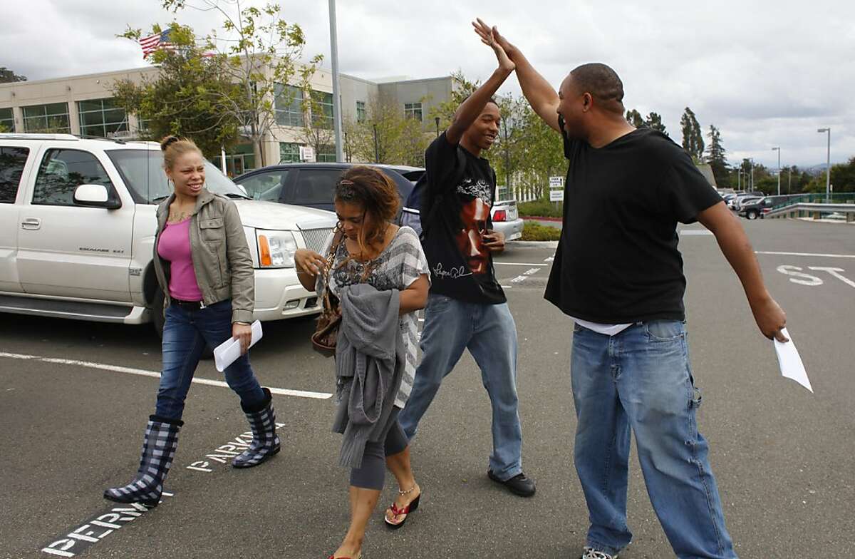 Ramon Price Sr., right, high-fives his oldest son Ramon Jr. outside the Alameda County Juvenile Justice center after regaining custody of his daughter Brijjanna, left, from foster care, Thursday April 12, 2012.  Brijjanna, 16 years old, went into foster care after fighting with her grandmother soon after her brother Lamont's killing. Photo: Lacy Atkins, The Chronicle