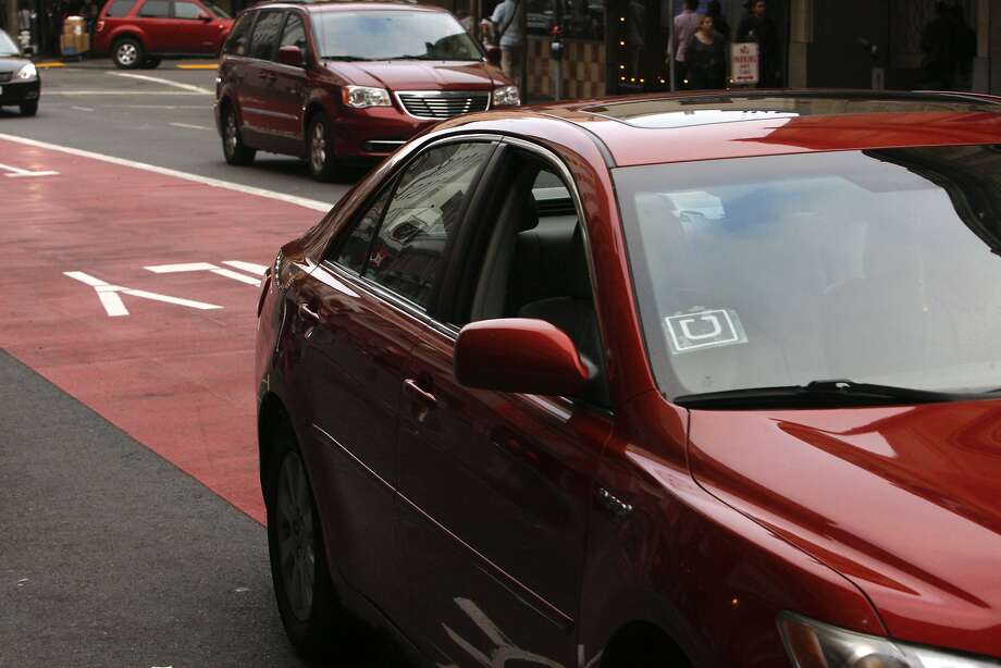 A red sedan bearing the distinctive "U" logo of the Uber ride-sharing service takes the transit lane on Geary Street in San Francisco on Friday, September 19, 2014. Photo: Terray Sylvester, The Chronicle