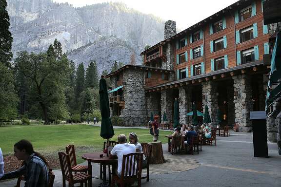 YOSEMITE NTL PARK, CA - AUGUST 28:  Park visitors sit outside of the Ahwahnee Hotel on August 28, 2013 in Yosemite National Park, California.  As the Rim Fire continues to burn on the western edge of Yosemite National Park, the valley floor of the park remains open. The Rim Fire has charred more than 190,000 acres of forest and is currently 30 percent contained.  (Photo by Justin Sullivan/Getty Images)