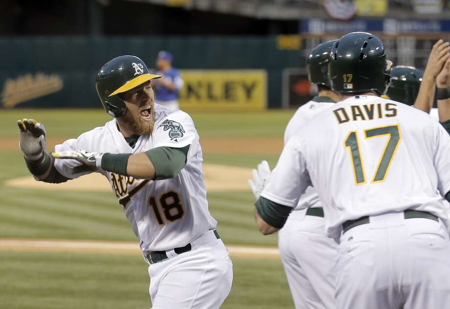 Ben Zobrist (18) reacts as he is congratulated by teammates after hitting a two-run homerun in the first inning as the Oakland Athletics played the Texas Rangers at O.Co Coliseum on Monday, April 6, 2015, in Oakland, Calif. Photo: Carlos Avila Gonzalez, The Chronicle