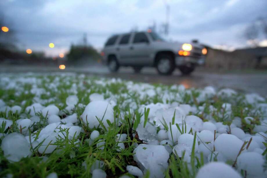 A vehicle drives by a field covered from a hail storm early Thursday, March 17, 2016 in Fort Worth, Texas.  Hail the size of golf balls coated parts of North Texas, broke windows, damaged police vehicles and killed exotic birds at the Fort Worth Zoo.   (Rodger Mallison/Star-Telegram via AP)  MAGS OUT; (FORT WORTH WEEKLY, 360 WEST); INTERNET OUT; MANDATORY CREDIT Photo: Rodger Mallison, MBI / Star-Telegram