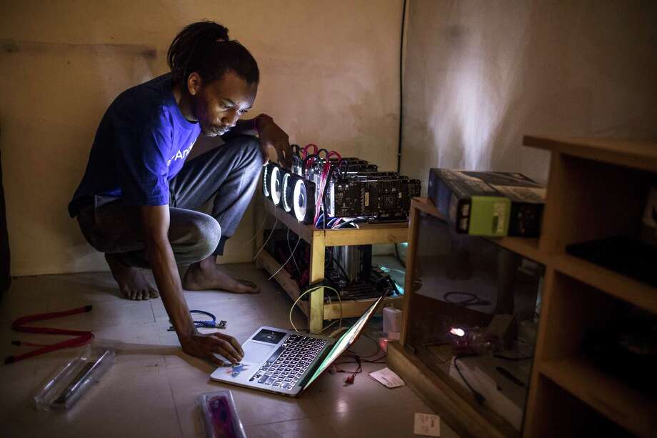 Eugene Mutai, bitcoin 'miner' and software developer, operates a laptop computer connected to a rack of cryptocurrency 'mining' machines at his home in Nairobi, Kenya, on Sept. 9, 2017. Photo: Bloomberg Photo By Luis Tato. / Â© 2017 Bloomberg Finance LP